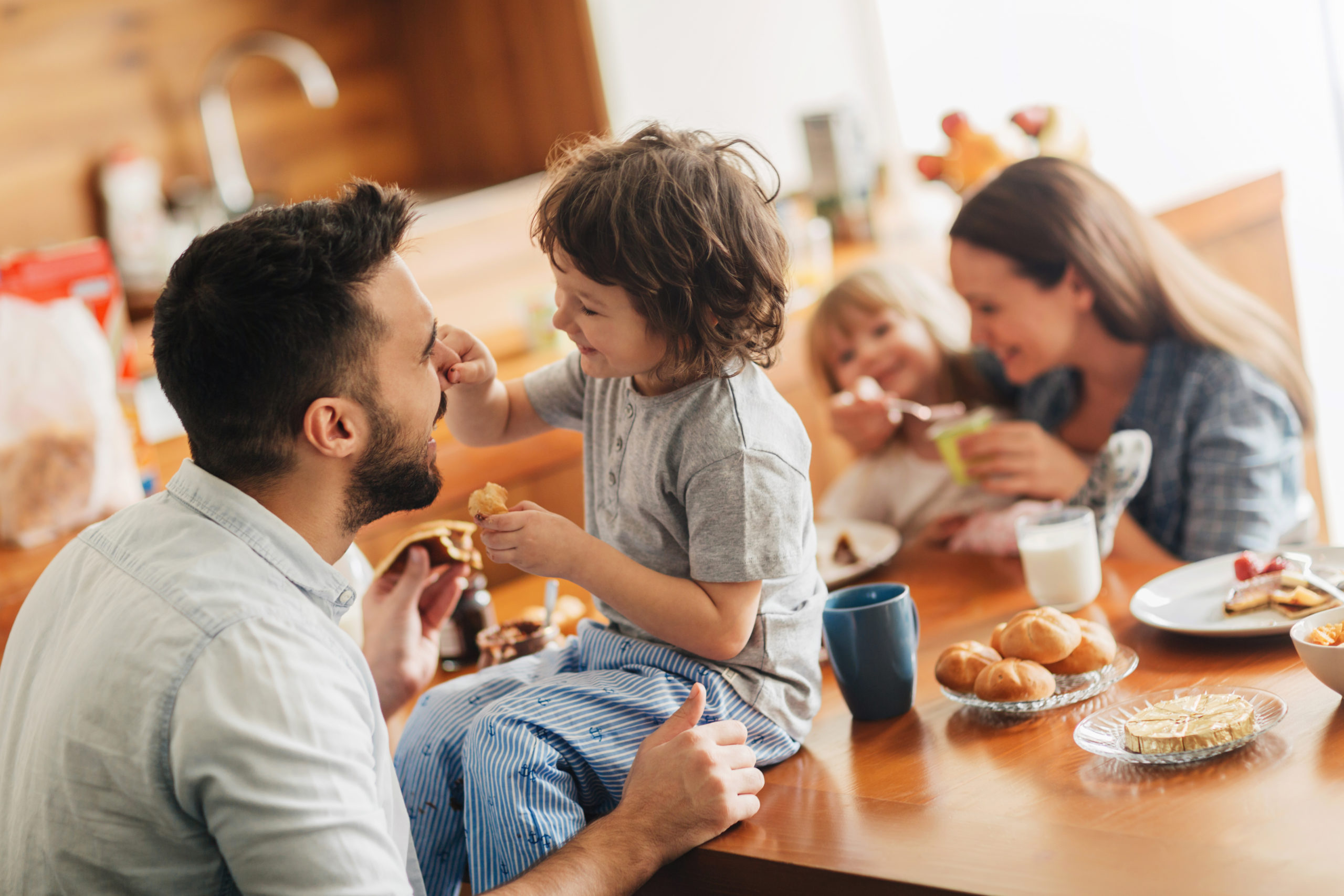 Photo of a young happy family having breakfast